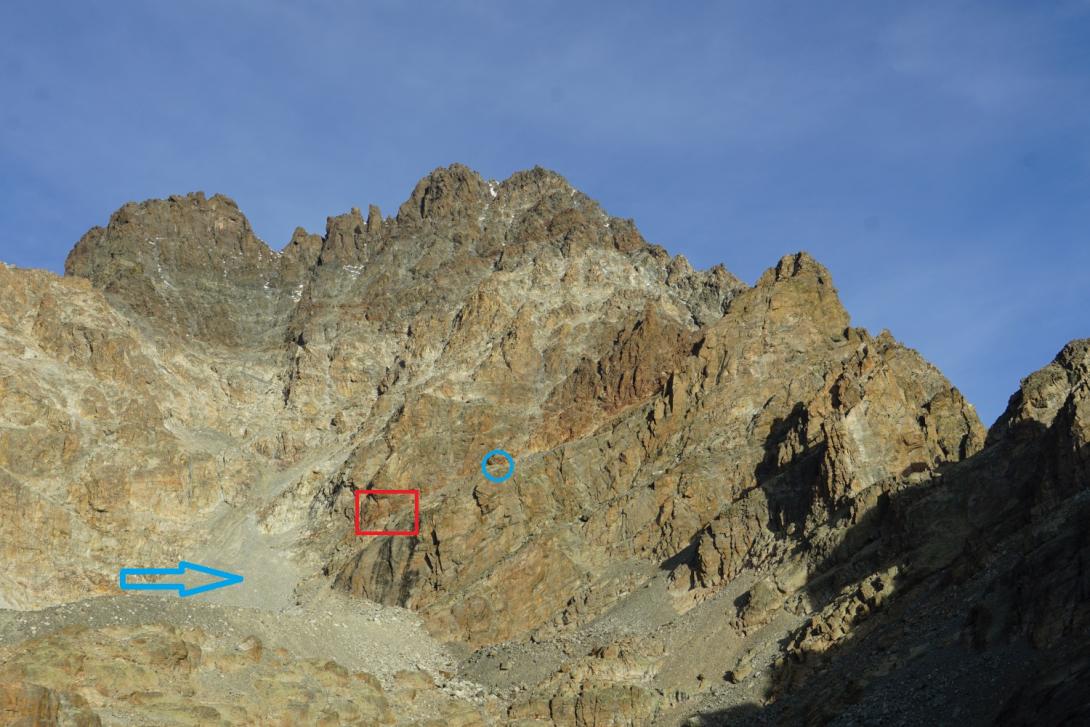 Panoramica del versante sud del Monviso ripreso dal Colle delle Sagnette. Freccia azzurra: settore un tempo occupato dal Ghiacciaio di Viso; rettangolo rosso: posizione del Bivacco Andreotti; cerchio azzurro: grotta di ghiaccio al bordo dell’area un tempo occupata dal Ghiacciaio Sella (29 ottobre 2022)